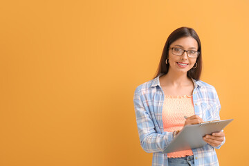 Wall Mural - Beautiful young woman with clipboard on color background