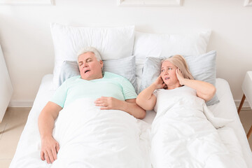 Sticker - Mature irritated woman in bed with snoring husband