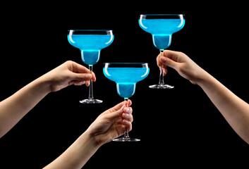 Wall Mural - Set of hands holding blue curacao margarita glass isolated on black.