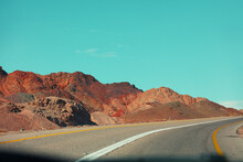Highway In The Mountain Desert. Sandstone Mountains Along The Road. View From Car