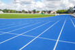 © OceanProd - Athletics running track blue treadmill in sport stadium field