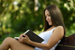 © Ranta Images - Happy beautiful Asian woman reading book at the park outdoors