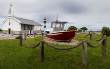 Red Fishing Boat, Lighthouse, And Church Of Ortiguera Asturias On The Atlantic Coast Of Spain