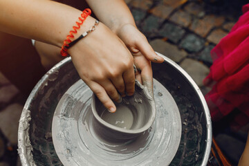 Potter make a small jug. Hands of a potter at work