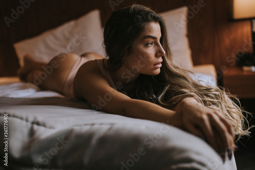 Fotomural Young woman in lingerie lying on the bed