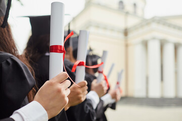 Wall Mural - Graduates with diplomas in front of the university.