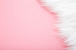 © fotoduets - Light, white fur on pastel pink table background. Empty place for text. Top down view.