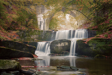 Wall Mural - vintage style autumn landscape - river waterfall in colorful autumn forest with old bridge