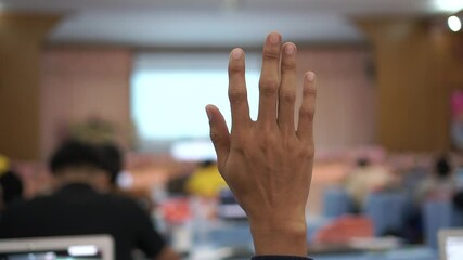 Wall Mural - hands of a man in a meeting, Audience raising hand while speaker on stage at conference to answer question while speaker speech at seminar hall with crowd groups in business and education