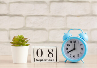 September 8. Wooden calendar with date and table clock with bells on the table or shelf. It's September.Early autumn.