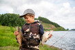 seven year old boy holds a fish he caught