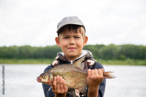 Fotomural seven year old boy holds a fish he caught
