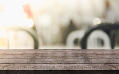 Empty wooden table top with lights bokeh on blur restaurant background