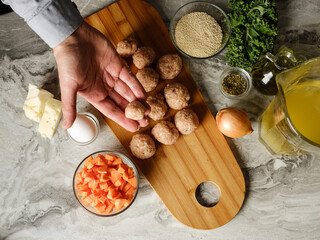 Wall Mural - Meatball cutlet cooking by homemade recipe with farm meat, organic vegetables, herbs and spices by man cook hands on kitchen background