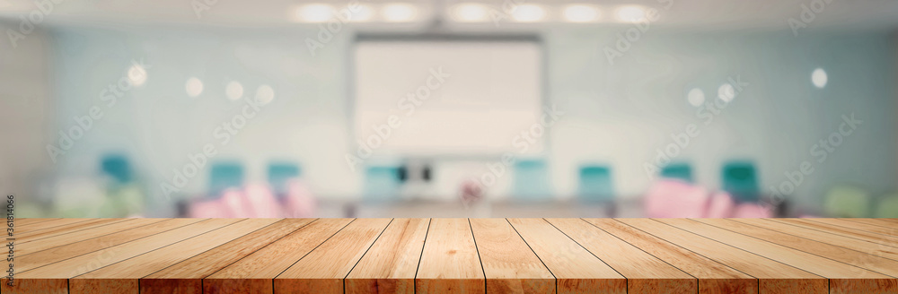 Panoramic empty clean wood counter table top on blur student study in classroom white light background for product education learning hall centre, Abstract Blurry wooden desk scene display or montage. - obrazy, fototapety, plakaty 