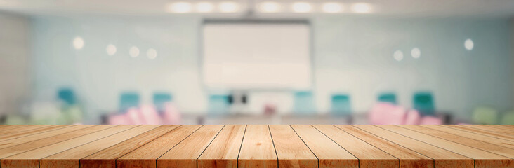 panoramic empty clean wood counter table top on blur student study in classroom white light backgrou