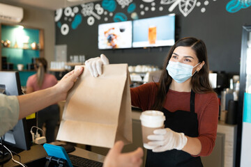 Wall Mural - Female Barista Giving Parcel And Coffee To Customer