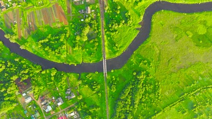 Wall Mural - Aerial view landscape of winding small river among the small town, stream in green field, top view meadow