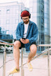 © mykolastock - Modern handsome bearded hipster male watching online course on smartphone in wireless headpnones