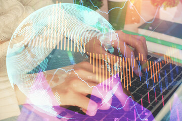 Double exposure of woman hands typing on computer and forex chart hologram drawing. Stock market invest concept.