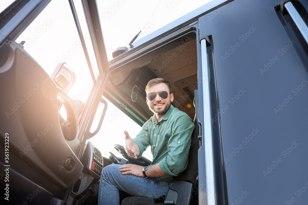 Young driver in cabin of big truck