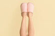 © Pixel-Shot - Female legs in soft slippers on color background