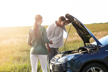 Wall Mural - Young couple near broken car on road