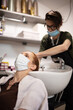 © astrosystem - Hairdresser and customer in a salon with medical masks during virus pandemic. Working with safety mask.