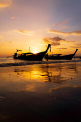 Wall Mural - Traditional long-tail boat on the beach in Thailand at sunset