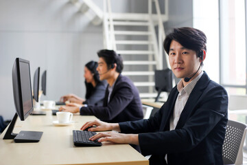 Asia Group of call center workers or Confident business team with headset in office.