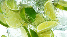 Lime Slices With Ice Cubes Falling Deeply Under Water