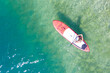 Bird's eye view to girl on SUP surf board on turquoise clean lake water at sunny summer day