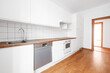 © hanohiki - empty,  white kitchen or kitchenette with parquetfloor and wooden tabletop