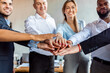© Prostock-studio - Coworkers Holding Hands Celebrating Business Success In Modern Office, Cropped