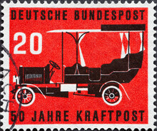 GERMANY - CIRCA 1955: This Postage Stamp Shows Shows A Post Bus From 1906 Against A Red Background. The Postage Stamp Was Published On The Occasion Of 50 Years Of Automobile Post. Circa 1955