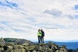 © anatoliy_gleb - Front view of loving couple hugging, posing and looking at camera, beautiful mountains scenery on background. Mountain hiking, tourists reaching peak together. Wild nature, sport tourism concept.