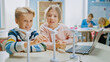 © Gorodenkoff - Schoolgirl and Schoolboy Work with Wind Turbine Prototype, Learning about Environment and Renewable Energy . Elementary School Science Classroom with Children Working on Technology. STEM Education
