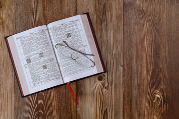 Wall Mural - Opened the Holy Bible close up prayer time on eyeglasses