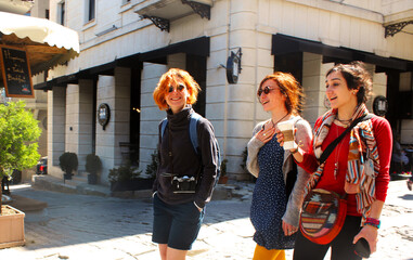 Young women walking with coffee cup at sunlight day in the street of Istanbul, Happy faces and travel scene.