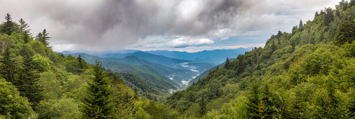 Thick morning clouds roll over the blue ridges of the Appalachian Range in Great Smoky Mountains National Park near the border of North Carolina and Tennessee. Shot from the Oconoluftee Overlook