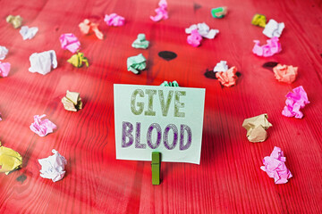 Handwriting text Give Blood. Conceptual photo an individual voluntarily has blood drawn and used for transfusions Colored crumpled rectangle shaped reminder paper light blue background