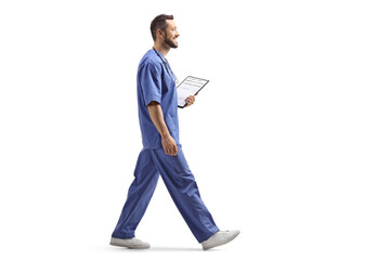 Wall Mural - Male health worker in a blue uniform walking and holding a clipboard