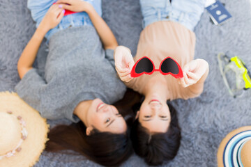 Two Asian women planning a summer vacation trip.