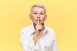 © Anatoliy Karlyuk - Portrait of stylish attractive middle aged businesswoman in white shirt holding fore finger on her lips, asking you to keep silent about commercial secret, making shh gesture. Mature female shushing