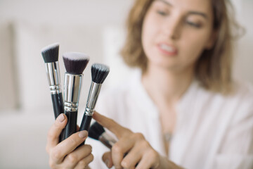 Makeup artist showing different brushes. Makeup lessons concept.