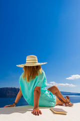 Wall Mural - Luxury travel vacation woman looking at view on Santorini island