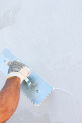 Wall Mural - Builder using plastering tool for finishing wall and floor.