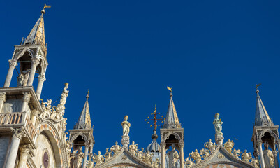 Wall Mural - St Mark`s Basilica or San Marco, detail of facade top on blue sky background, Venice, Italy.