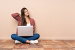 © luismolinero - Teenager student girl sitting on the floor with a laptop with neckache