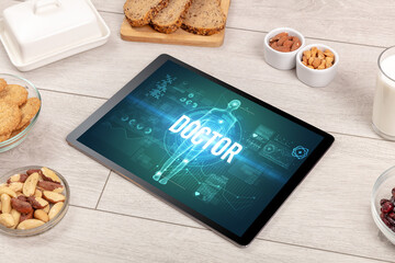 DOCTOR concept in tablet with fruits, top view